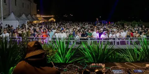 Un DJ suona per una folla entusiasta a uno dei tanti festival musicali in Italia.