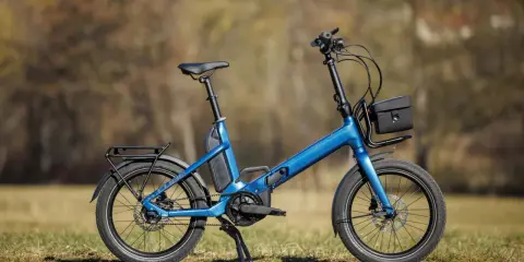 Blaues Cube Fold Hybrid 500 E-Bike im Test, mit Gepäckträger und Tasche.