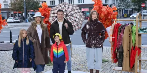 Rodzina prezentuje stylowe stylizacje na deszczowe dni: płaszcze, kalosze i kolorowe parasole.
