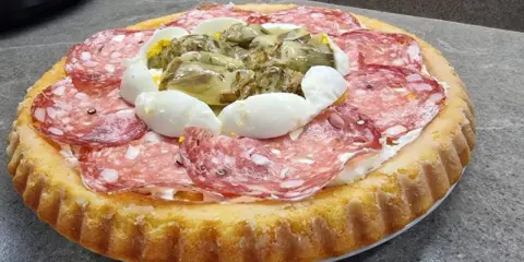 Crostata morbida salata con salame, uova sode e carciofini sott'olio, un'idea gustosa per un aperitivo o un antipasto.
