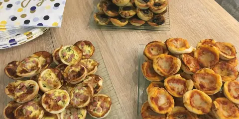 Plateaux de mini-pizzas et quiches, parfaits pour une idée repas crémaillère conviviale.