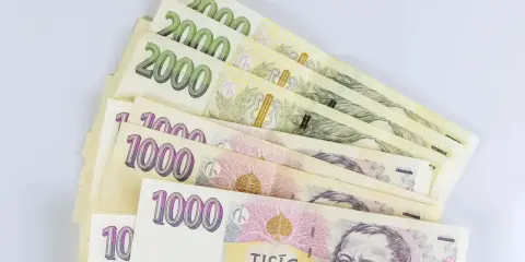 Kupka banknotów 1000 i 2000 koron czeskich, waluta w Czechach, leży na białym tle.