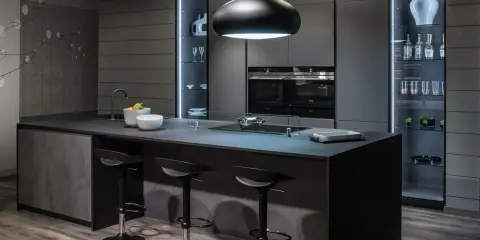 Cucina moderna con isola centrale e sgabelli. Il grigio scuro domina, creando un'atmosfera sofisticata. Perfetto per chi cerca idee su come abbinare il grigio scuro con stile.