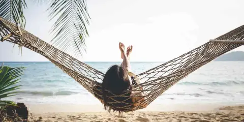 Relaks na plaży w hamaku, idealny opis wakacji po angielsku. Słońce, morze i palmy tworzą rajski widok.