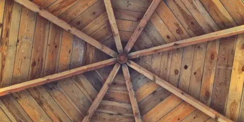 Estructura radial de vigas de madera que se unen en el centro, formando unos techos de madera rústicos y acogedores.