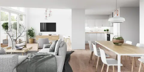 Nowoczesny, prostokątny salon z jadalnią. Jasne wnętrze z wygodną sofą, stołem i krzesłami, a w tle otwarta kuchnia.