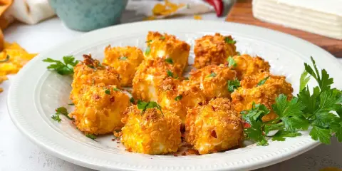 Knusprig panierte Feta-Würfel, im Airfryer zubereitet, garniert mit Petersilie. Ein köstlicher Snack!