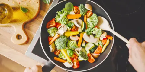 Verduras salteadas en sartén, ideal para una dieta helicobacter pylori. Brócoli, zanahoria, champiñones y tomate.