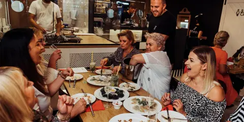 Grupa kobiet cieszy się posiłkiem. DJ gra muzykę. Usługa cateringowa, jaki VAT?