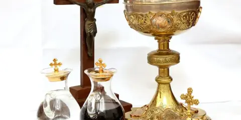 Kielich, krzyż i ampułki z winem i wodą. Zastanawiasz się, ile kosztuje msza za zmarłego?
