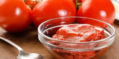 Färska tomater och en skål med tomatpuré, perfekt för ditt tomatpuré recept.