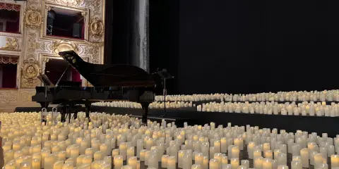 Un pianoforte su un palco ricoperto di candele, un'atmosfera magica di candlelight a Rimini.