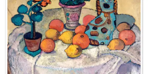 Paula Modersohn-Becker målade ett stilleben med en blå hundfigur, frukter och blommor på ett dukklätt bord.