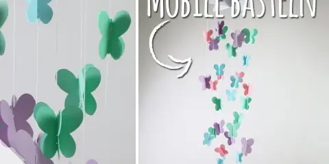 Bunte Schmetterlinge aus Papier hängen an Schnüren und bilden ein Mobile. Hier gibt es kostenlose mobile basteln vorlagen!