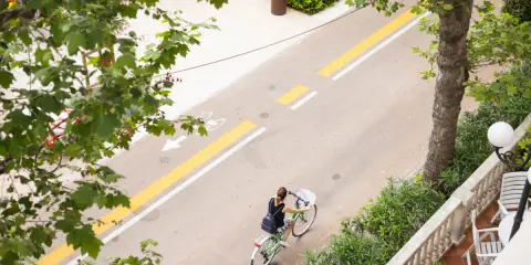 Una donna in bicicletta percorre il lungomare di San Mauro Mare, su una pista ciclabile ben segnalata.