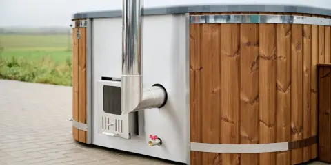 En badtunna hybrid med träpanel och metall, redo för ett avkopplande bad utomhus.