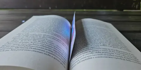 Un libro aperto, con pagine che sembrano sussurrare storie, forse della saga "50 sfumature".