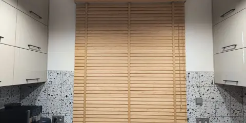 Drewniane żaluzje do kuchni idealnie komponują się z nowoczesnymi meblami i płytkami.