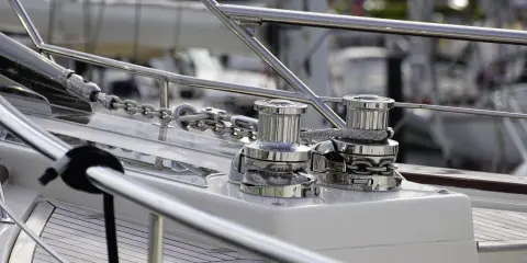 Deux winches chromés sur un bateau, prêts à hisser la chaîne de l'ancre. Le schema guindeau est bien visible.