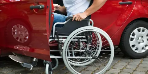 Autista con patente B, in sedia a rotelle, si prepara per la consegna di medicinali.