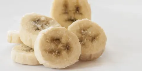 Ein Haufen gefrorener Bananenscheiben, bereit zum Einfrieren für Smoothies oder Desserts.