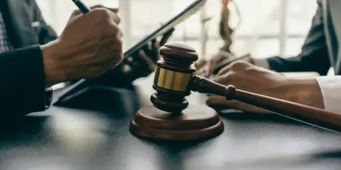 Sędzia sądu, młotek i dokumenty. Droga do tego zawodu wymaga wiedzy i doświadczenia.