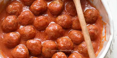 Polpette di carne morbide e succulente, immerse in un sugo rosso invitante, pronte per essere gustate.