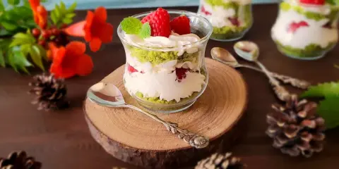 Pyszne ciasto leśny mech na dużą blachę z serkiem mascarpone, podane w szklanych pucharkach, ozdobione malinami i miętą.