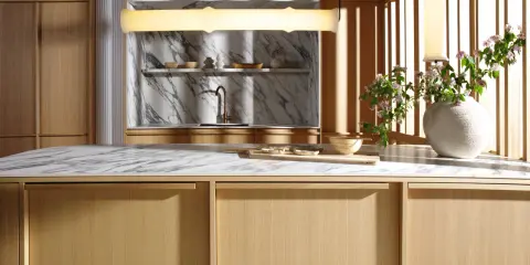 Minimalistyczna kuchnia japandi z drewnianymi frontami, marmurowym blatem i subtelnymi dodatkami.