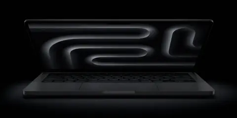 MacBook Pro z polskim układem klawiatury, ciemny ekran z abstrakcyjnym wzorem.