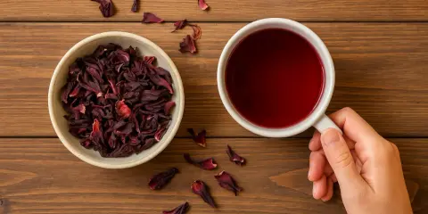 Miseczka suszonego hibiskusa i kubek czerwonego naparu. To jakby hibiskus w ciąży, gotowy do rozkwitu w aromatycznym napoju.