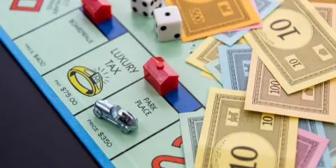 Na planszy Monopoly leżą pionki, kostki i banknoty. Czas na wielką rozgrywkę, ale gramy!