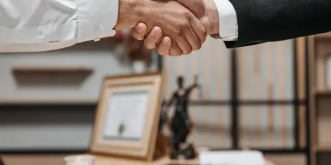Uścisk dłoni symbolizujący udaną współpracę. Nowa automatyk praca czeka na specjalistów.
