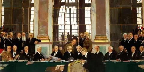 Podpisanie traktatu wersalskiego, które miało dalekosiężne skutki dla Europy. Mężczyźni w garniturach i mundurach siedzą przy zielonym stole.