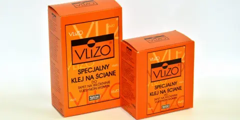 Dwa opakowania kleju do tapet flizelinowych VLIZO, specjalnego do tapet na włókninie, w jaskrawym pomarańczowym kolorze.