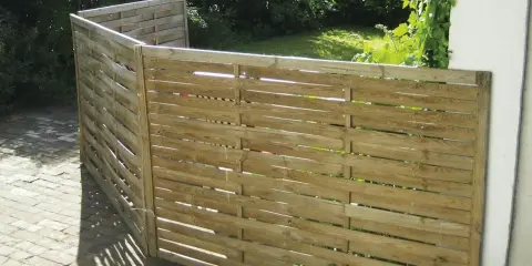 Ett enkelt vindskydd av trä, perfekt för att bygga en mysig vrå i trädgården.