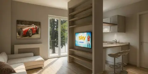 Soggiorno moderno con divano, quadro d'auto d'epoca e cucina a vista. Perfetto per chi cerca case ristrutturate con stile.