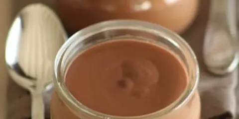 Un pot de crème chocolat onctueuse, prêt à être dégusté avec une cuillère.