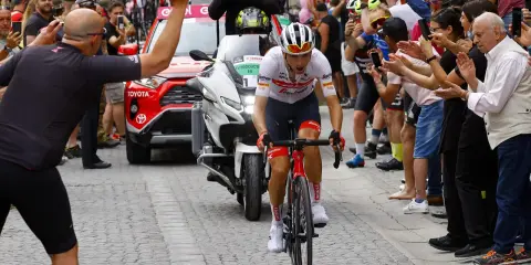 Giulio Ciccone fährt auf seinem Rennrad durch eine Gasse, umgeben von jubelnden Zuschauern und Motorrädern.