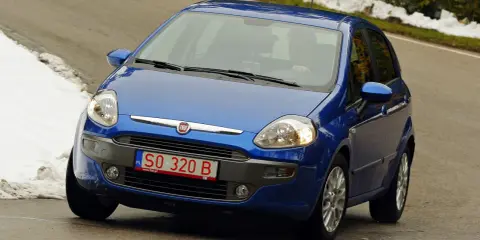Niebieski Fiat z polskimi tymczasowymi tablicami rejestracyjnymi SO 320 B jedzie po krętej drodze, po bokach śnieg.