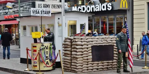 Checkpoint Charlie, ett måste att se i Berlin, med soldater och en McDonald's i bakgrunden.
