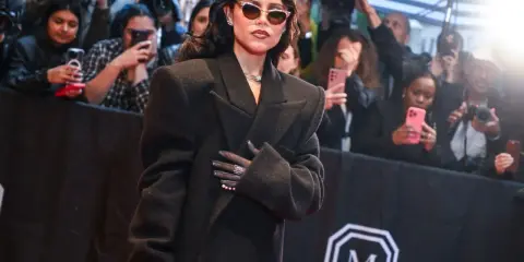 Jenna Ortega deslumbró en la Met Gala con un elegante abrigo negro y gafas de sol.
