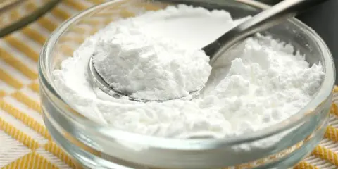 Sypki cukier puder w szklanej miseczce, gotowy do użycia. Dowiedz się, jak zrobić cukier puder w domu!