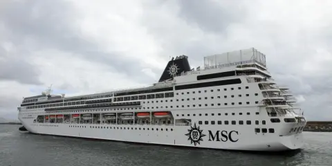 La MSC Sinfonia, con la sua impressionante lunghezza, solca le acque grigie sotto un cielo nuvoloso.