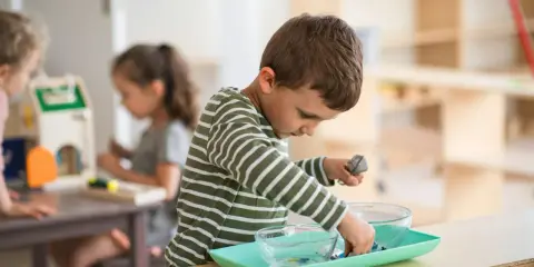 Niño concentrado en actividad de trasvase en un aula Montessori España.