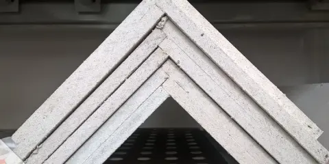Stapel von Fermacell Platten, bereit zum Streichen. Die Platten sind im Winkel angeordnet und zeigen ihre Kanten.