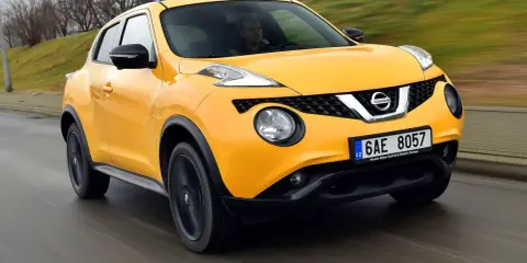 Żółty Nissan Juke 1.6 benzyna w ruchu ulicznym.