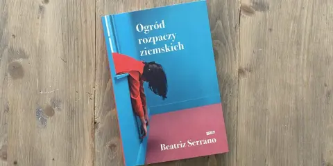 Okładka książki "Ogród rozpaczy ziemskich" z postacią w czerwonej bluzce opierającą się o niebieską ścianę.