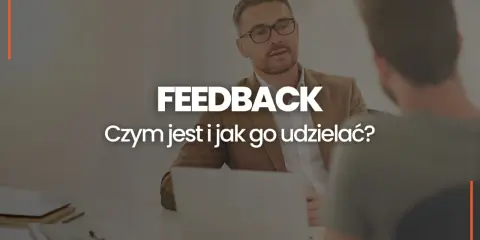 Dwóch mężczyzn przy biurku, jeden z nich udziela feedbacku. Czym jest feedback i jak go udzielać?