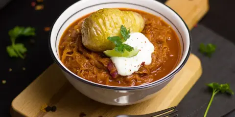 Un plat réconfortant de cuisine des terroirs aujourd'hui : choucroute garnie avec une pomme de terre Hasselback et une touche de crème.